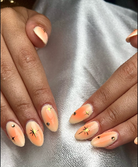 Unhas em degradé pêssego com estrelas